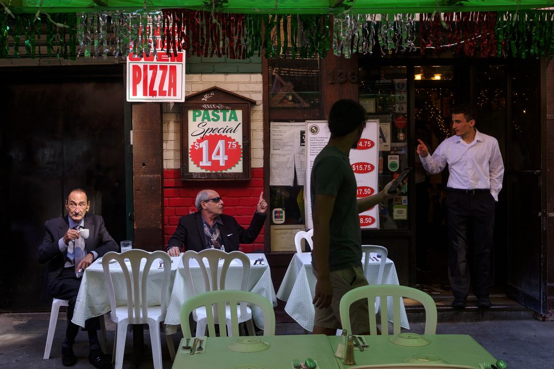 Salvatore Rinaldi, center, a co-owner of the Paesano restaurant on Mulberry, talks to a waiter while with his friend  Dimitri Vassilopoulos. The Feast of San Gennaro in the Little Italy neighborhood of Manhattan.